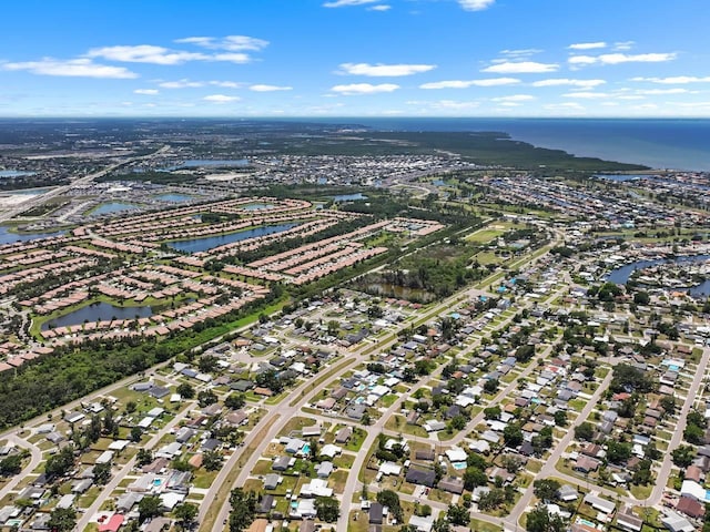 aerial view of property's location featuring a nearby body of water and nearby suburban area