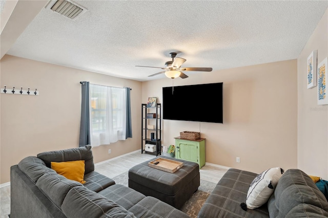 8497 Portulaca Ave, Seminole, FL 33777 - living area featuring a ceiling fan, a textured ceiling, baseboards, and wood finished floors