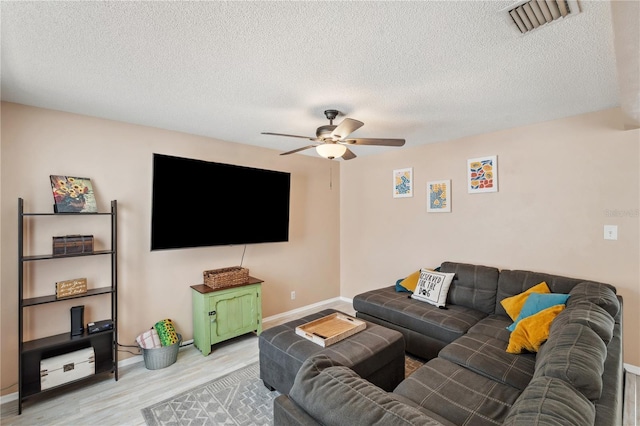 8497 Portulaca Ave, Seminole, FL 33777 - living area with ceiling fan, light wood-style flooring, baseboards, and a textured ceiling