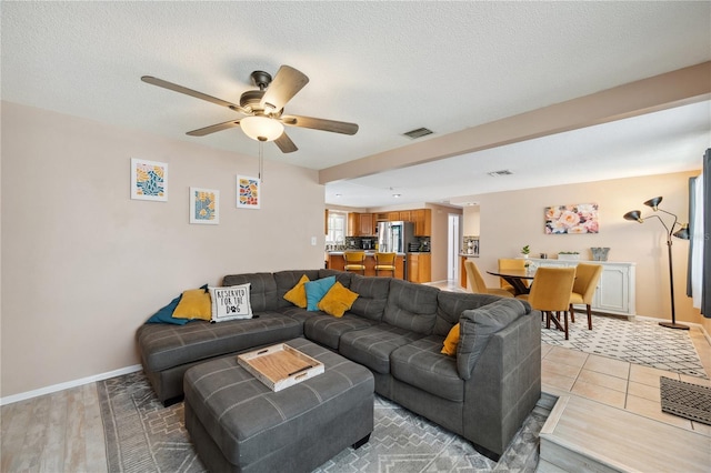 8497 Portulaca Ave, Seminole, FL 33777 - living room featuring ceiling fan, baseboards, and a textured ceiling
