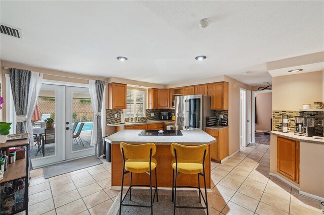 8497 Portulaca Ave, Seminole, FL 33777 - kitchen with stainless steel fridge with ice dispenser, a sink, tasteful backsplash, light tile patterned floors, and recessed lighting