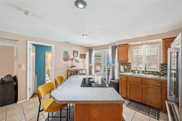 8497 Portulaca Ave, Seminole, FL 33777 - kitchen with a sink, light tile patterned flooring, a breakfast bar, decorative backsplash, and plenty of natural light