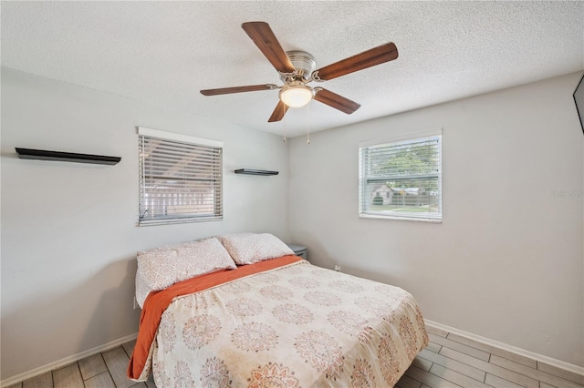 8497 Portulaca Ave, Seminole, FL 33777 - bedroom featuring wood finished floors, baseboards, a textured ceiling, and ceiling fan