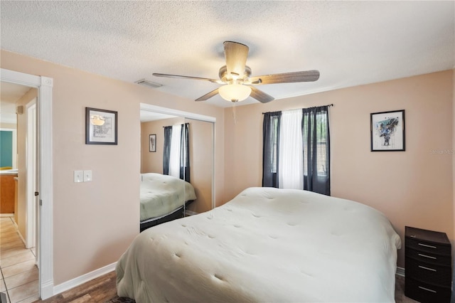 8497 Portulaca Ave, Seminole, FL 33777 - bedroom with a closet, a ceiling fan, a textured ceiling, and baseboards