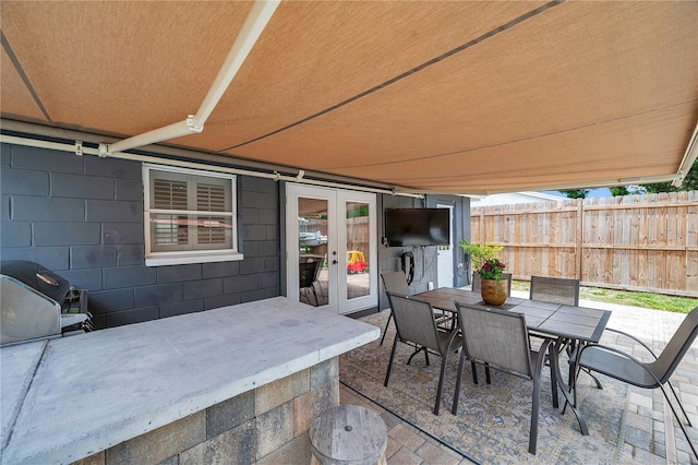 8497 Portulaca Ave, Seminole, FL 33777 - view of patio with fence, outdoor dining space, french doors, and area for grilling
