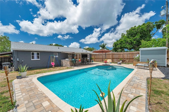 8497 Portulaca Ave, Seminole, FL 33777 - view of swimming pool with a patio, a fenced backyard, an outbuilding, and a storage shed