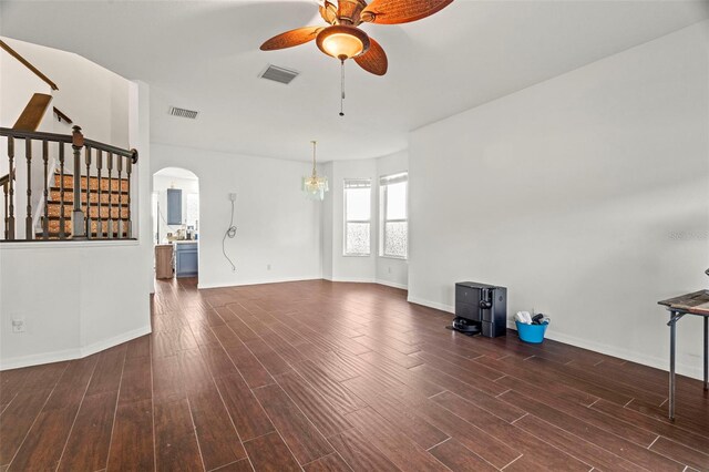 2832 Brinley Dr, New Port Richey, FL 34655 - unfurnished living room featuring a ceiling fan, arched walkways, stairs, dark wood finished floors, and baseboards