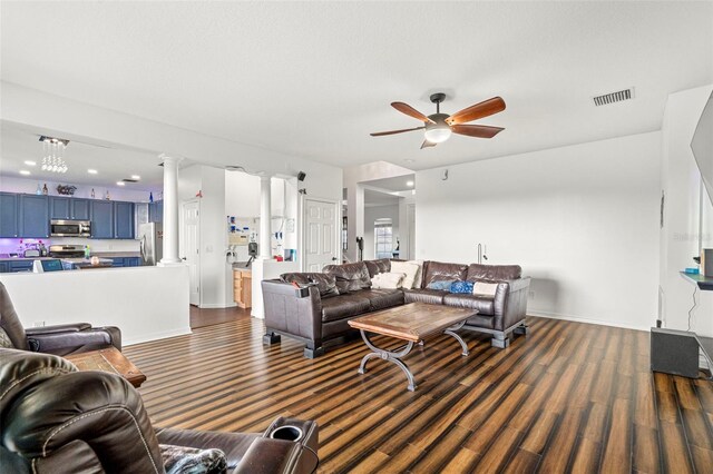 2832 Brinley Dr, New Port Richey, FL 34655 - living area with ornate columns, a ceiling fan, baseboards, and dark wood finished floors