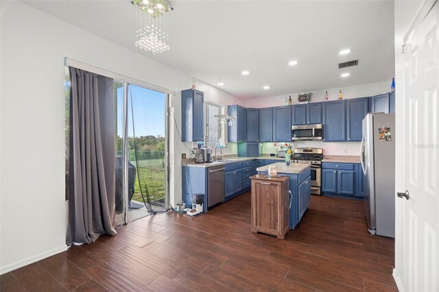 2832 Brinley Dr, New Port Richey, FL 34655 - kitchen with appliances with stainless steel finishes, a kitchen island, light countertops, blue cabinets, and a chandelier