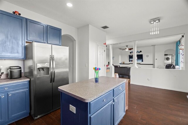 2832 Brinley Dr, New Port Richey, FL 34655 - kitchen with stainless steel fridge, blue cabinets, stacked washing machine and dryer, dark wood finished floors, and a ceiling fan