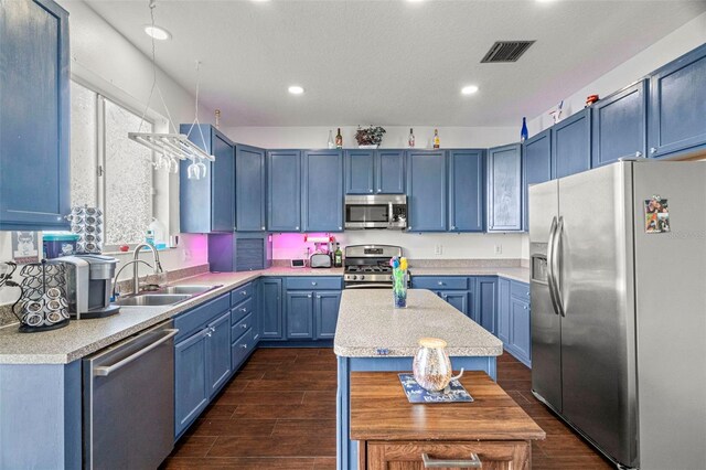2832 Brinley Dr, New Port Richey, FL 34655 - kitchen with stainless steel appliances, a sink, blue cabinets, light countertops, and recessed lighting