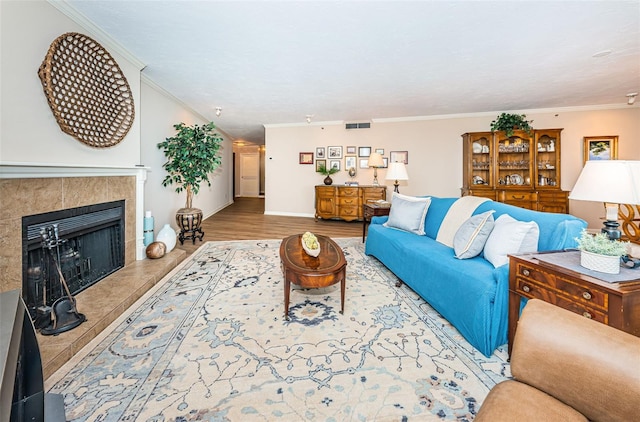 1600 Gulf Blvd Unit 514, Clearwater Beach, FL 33767 - living area with ornamental molding, a tile fireplace, baseboards, and wood finished floors