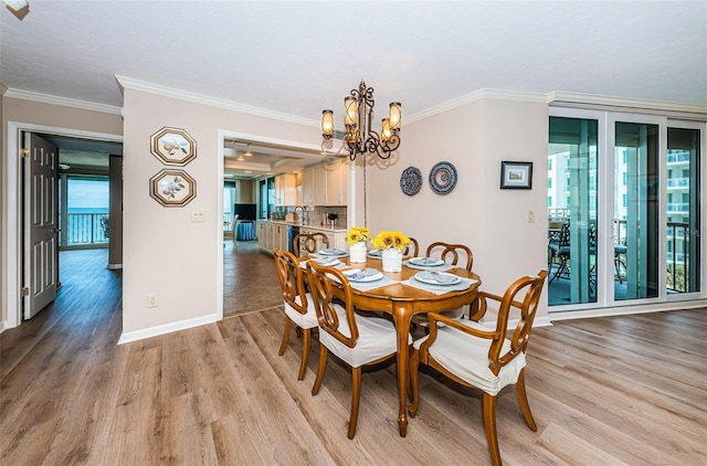 1600 Gulf Blvd Unit 514, Clearwater Beach, FL 33767 - dining room featuring a chandelier, light wood-style floors, ornamental molding, and baseboards