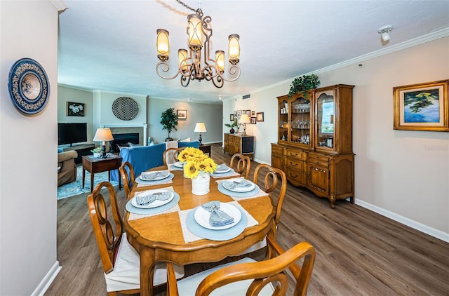 1600 Gulf Blvd Unit 514, Clearwater Beach, FL 33767 - dining room with baseboards, wood finished floors, ornamental molding, a chandelier, and a fireplace