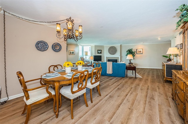 1600 Gulf Blvd Unit 514, Clearwater Beach, FL 33767 - dining space featuring ornamental molding, light wood finished floors, baseboards, a fireplace, and a chandelier