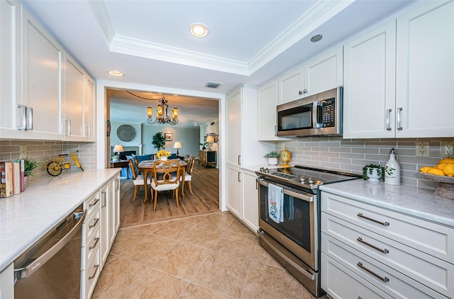 1600 Gulf Blvd Unit 514, Clearwater Beach, FL 33767 - kitchen featuring stainless steel appliances, ornamental molding, recessed lighting, light countertops, and white cabinets