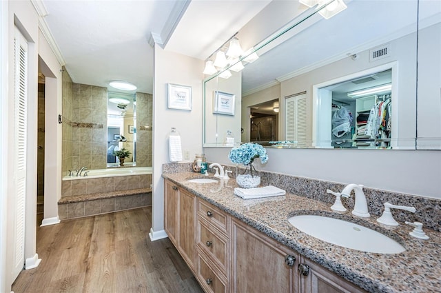 1600 Gulf Blvd Unit 514, Clearwater Beach, FL 33767 - full bathroom featuring wood finished floors, double vanity, ornamental molding, tiled bath, and a walk in closet