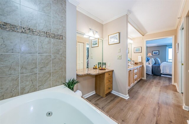 1600 Gulf Blvd Unit 514, Clearwater Beach, FL 33767 - bathroom with ensuite bathroom, wood finished floors, ornamental molding, vanity, and a tub