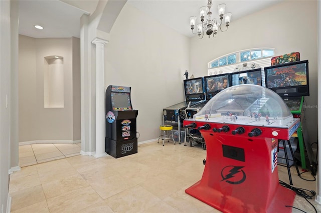 recreation room featuring ornate columns, arched walkways, a chandelier, baseboards, and tile patterned flooring