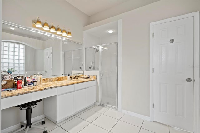 full bathroom featuring a stall shower, tile patterned floors, baseboards, and vanity