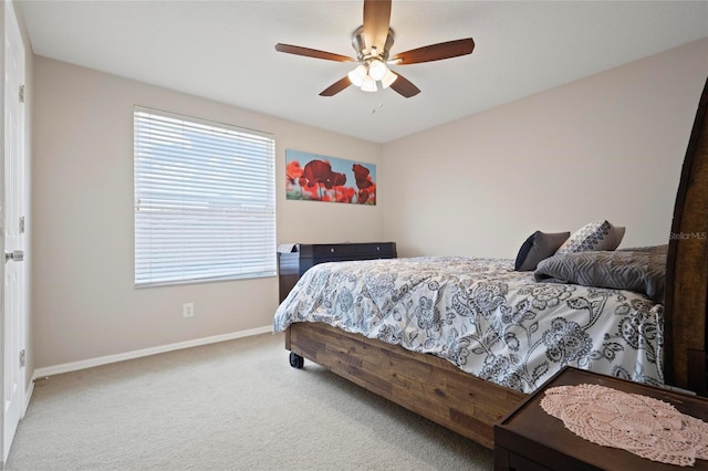 carpeted bedroom featuring baseboards, multiple windows, and a ceiling fan
