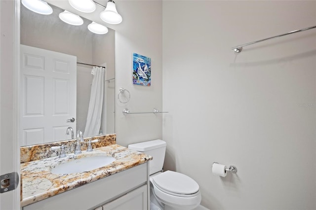 full bath featuring toilet, vanity, and curtained shower