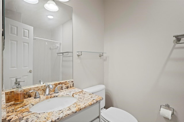 full bath with toilet, vanity, and a shower
