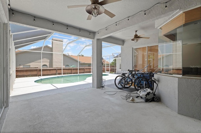 view of swimming pool with a ceiling fan, a patio, a lanai, and fence