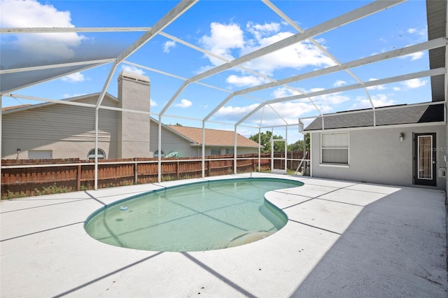 view of pool with fence, a patio, and glass enclosure