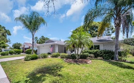 2113 Malcolm Dr, Palm Harbor, FL 34684 - view of front of property featuring an attached garage, a front yard, and concrete driveway