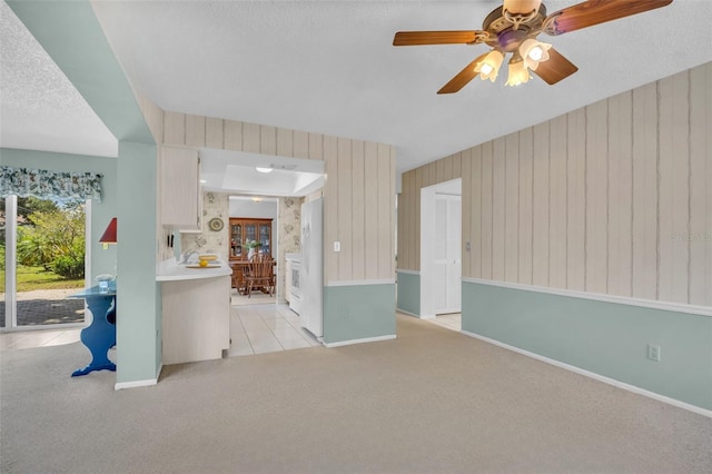 2113 Malcolm Dr, Palm Harbor, FL 34684 - unfurnished living room featuring light carpet, a ceiling fan, baseboards, and a textured ceiling