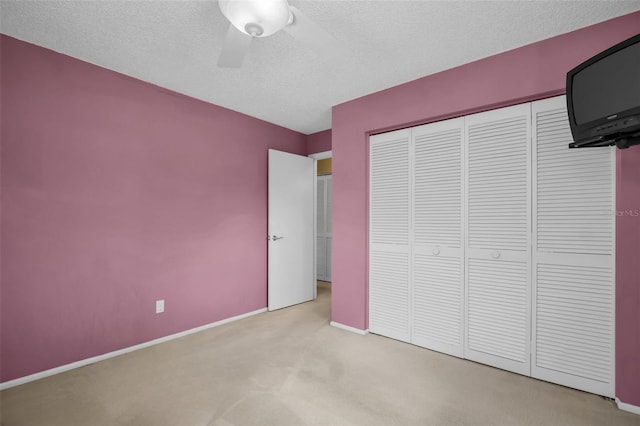 2113 Malcolm Dr, Palm Harbor, FL 34684 - unfurnished bedroom with carpet, a textured ceiling, a closet, baseboards, and ceiling fan