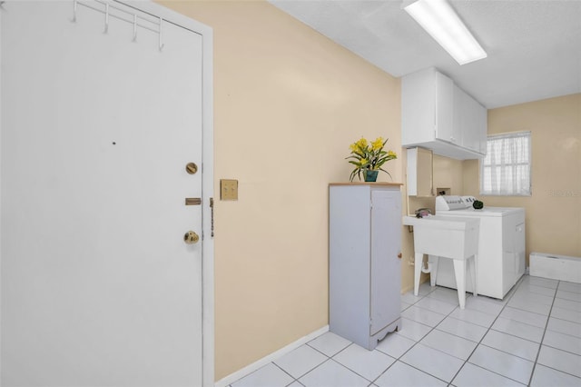 2113 Malcolm Dr, Palm Harbor, FL 34684 - clothes washing area featuring washer / dryer, cabinet space, light tile patterned flooring, and baseboards