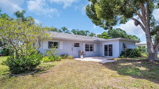 2113 Malcolm Dr, Palm Harbor, FL 34684 - rear view of property featuring stucco siding, a yard, and a patio area