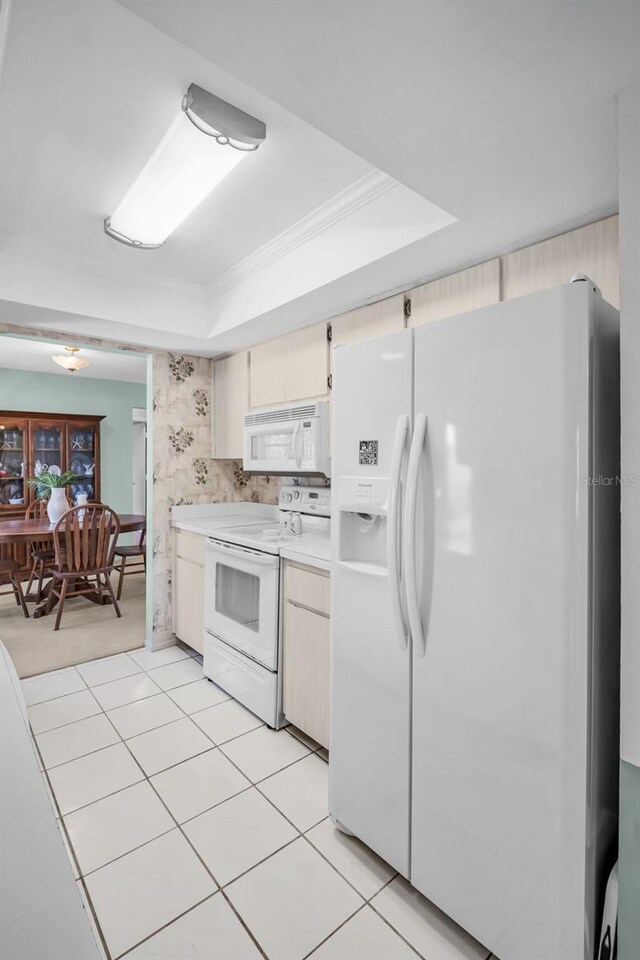 2113 Malcolm Dr, Palm Harbor, FL 34684 - kitchen featuring white appliances, a raised ceiling, light countertops, and ornamental molding