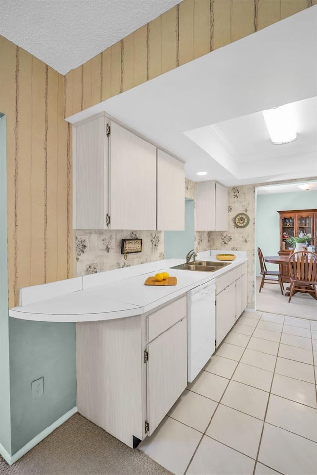 2113 Malcolm Dr, Palm Harbor, FL 34684 - kitchen with dishwasher, a sink, light countertops, baseboards, and a raised ceiling