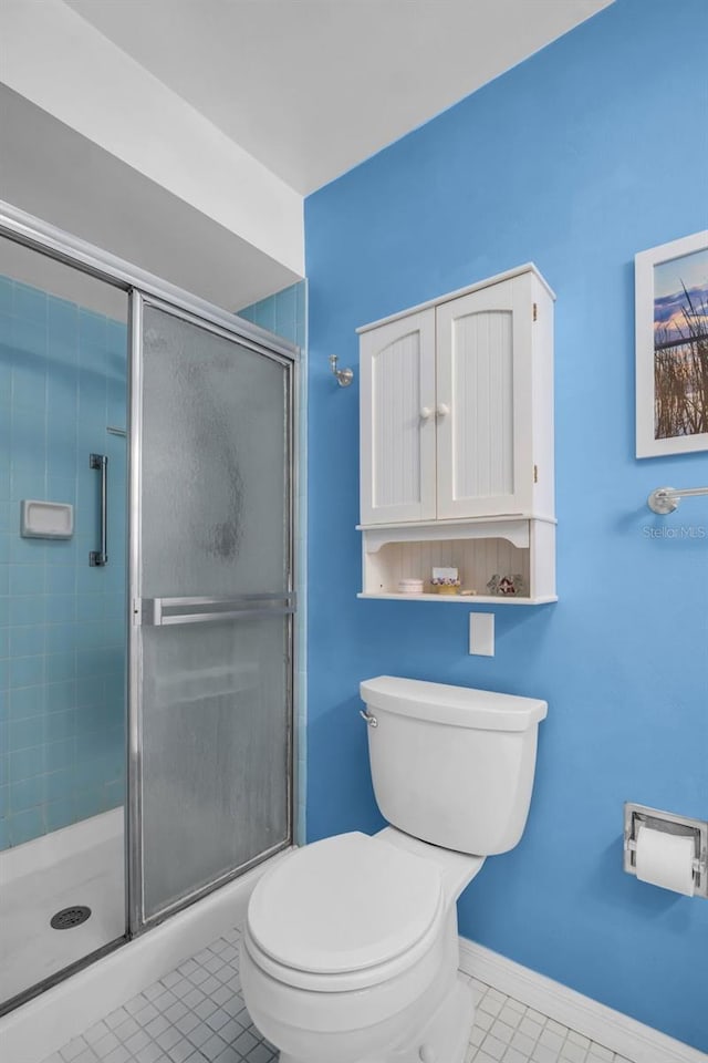 2113 Malcolm Dr, Palm Harbor, FL 34684 - bathroom featuring tile patterned flooring, toilet, a stall shower, and baseboards