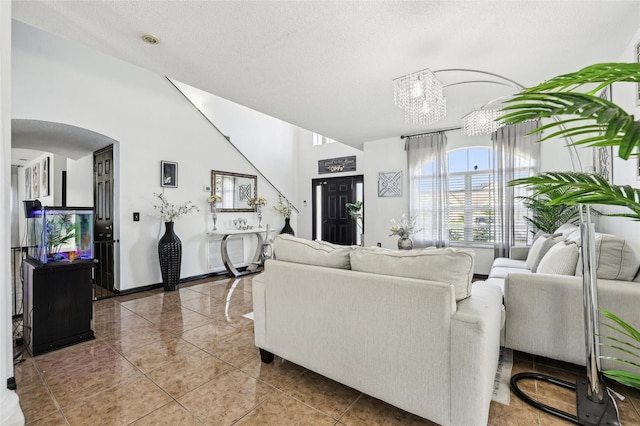 4422 Evergreen Forest Loop, Kissimmee, FL 34758 - living area featuring arched walkways, lofted ceiling, a chandelier, and a textured ceiling