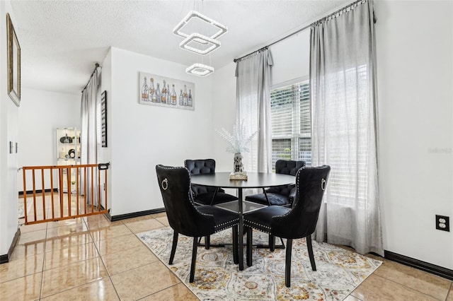 4422 Evergreen Forest Loop, Kissimmee, FL 34758 - dining area with light tile patterned floors, a chandelier, a textured ceiling, and baseboards