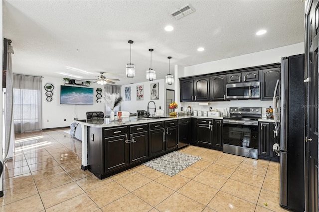 4422 Evergreen Forest Loop, Kissimmee, FL 34758 - kitchen with appliances with stainless steel finishes, a sink, light countertops, a peninsula, and a ceiling fan