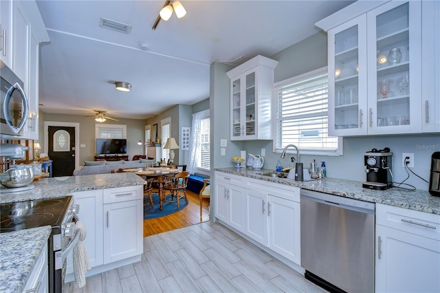 902 W Columbus Dr, Tampa, FL 33602 - kitchen with appliances with stainless steel finishes, a sink, a ceiling fan, open floor plan, and white cabinets