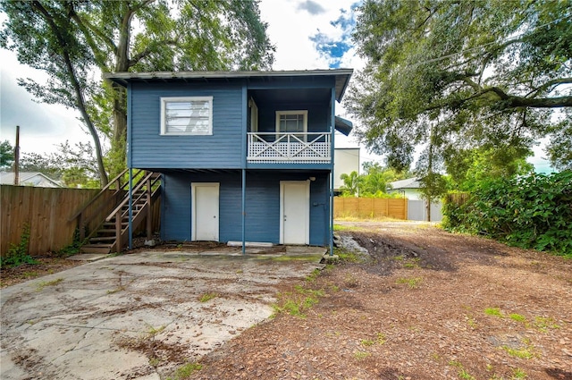 902 W Columbus Dr, Tampa, FL 33602 - view of front of house featuring fence, stairway, a storage unit, driveway, and a balcony