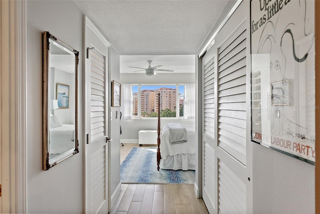 700 Beach Dr NE Unit 704, Saint Petersburg, FL 33701 - corridor with light wood-style flooring, a textured ceiling, and baseboards