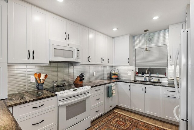 700 Beach Dr NE Unit 704, Saint Petersburg, FL 33701 - kitchen featuring white appliances, a sink, white cabinets, backsplash, and recessed lighting