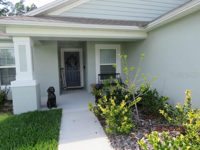 206 Samantha Ave, Auburndale, FL 33823 - property entrance with a porch, stucco siding, and roof with shingles