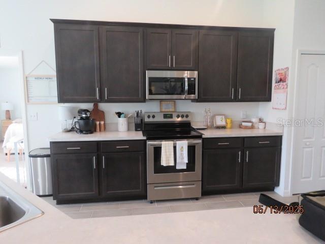 206 Samantha Ave, Auburndale, FL 33823 - kitchen with stainless steel appliances, light countertops, and dark brown cabinetry