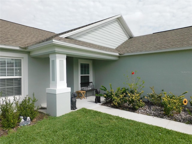 206 Samantha Ave, Auburndale, FL 33823 - doorway to property with a shingled roof, stucco siding, and a yard