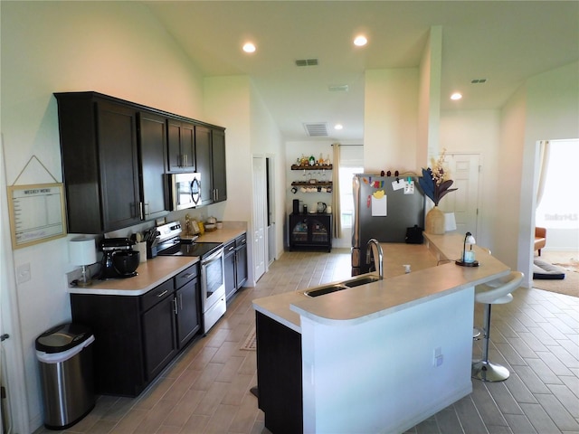 206 Samantha Ave, Auburndale, FL 33823 - kitchen with stainless steel appliances, a kitchen breakfast bar, wood finish floors, light countertops, and recessed lighting