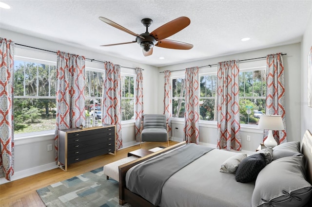 5632 Indiana Ave, New Port Richey, FL 34652 - bedroom with multiple windows, wood finished floors, a textured ceiling, baseboards, and recessed lighting