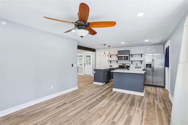 5632 Indiana Ave, New Port Richey, FL 34652 - kitchen featuring appliances with stainless steel finishes, open shelves, light countertops, backsplash, and light wood-type flooring
